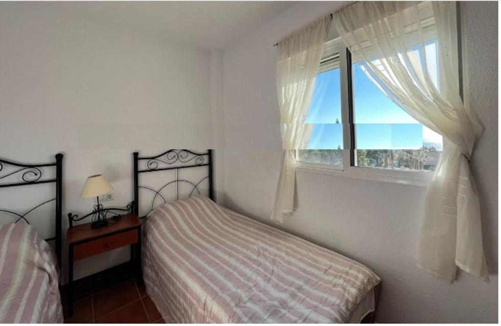 1 dormitorio con cama y ventana en La Azohía - El Pinar de San Ginés en La Azohía