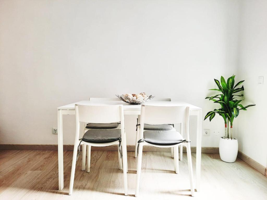 uma mesa de jantar branca com 4 cadeiras em Faro Casa da Baixa em Faro