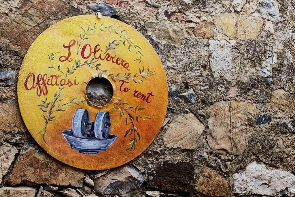 ein Schild an einer Steinmauer mit einem Bild von Kaktus in der Unterkunft L'Oliviera, Pari in Pari