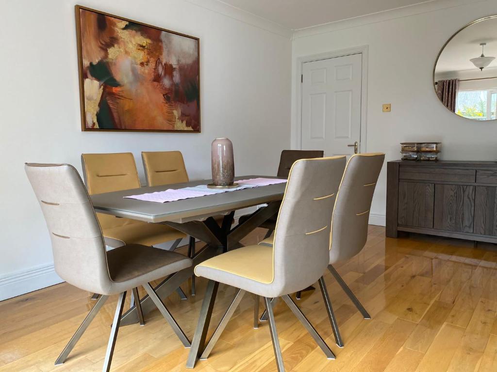 a dining room table with chairs and a painting on the wall at Foxborough BnB in Droichead an Chaisleáin