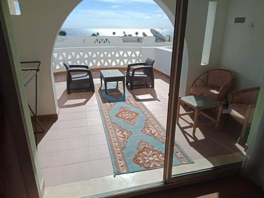 mit Blick auf einen Balkon mit Stühlen und einem Teppich in der Unterkunft appartamento di lusso con terrazzo vista mare in Sharm El Sheikh