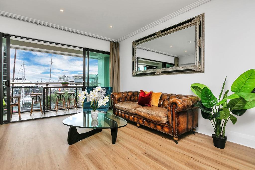 un soggiorno con divano e tavolo in vetro di Glamorous Getaway - Heart of the Viaduct 'Quays' ad Auckland