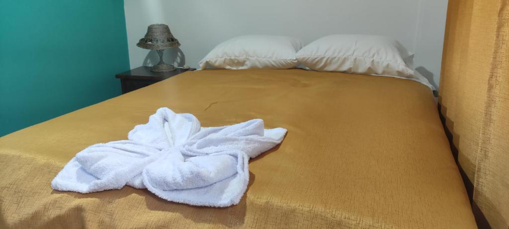 a bed with a white towel on it at Casa D´Maria in Ollantaytambo