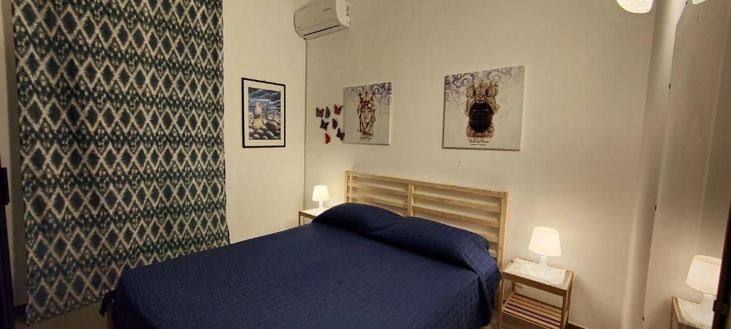 a bedroom with a blue bed and posters on the wall at Elegant Villa with Private Pool in Alcamo Marina – Sea View in Alcamo Marina