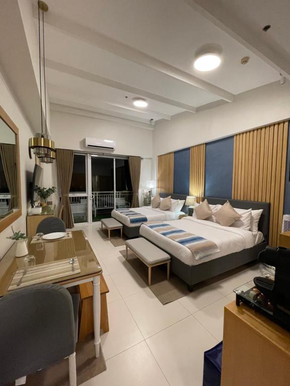 a bedroom with a large bed and a living room at 1BD 1BA PENTHOUSE 2X QUEEN in Nasugbu