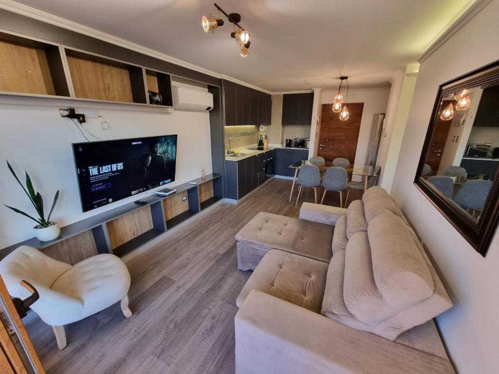un soggiorno con divano e TV di Depto 2D+2B amoblado y equipado. a Los Ángeles