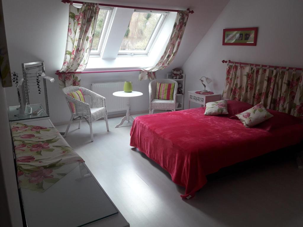 een slaapkamer met een rood bed en een raam bij Chambre d'hôte avec piscine couverte in Coulaines