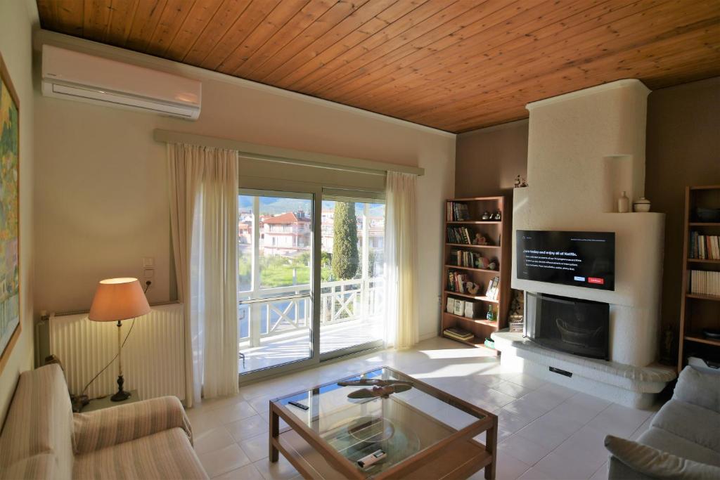 a living room with a glass table and a fireplace at Mata's Spacious Apartment in Astros