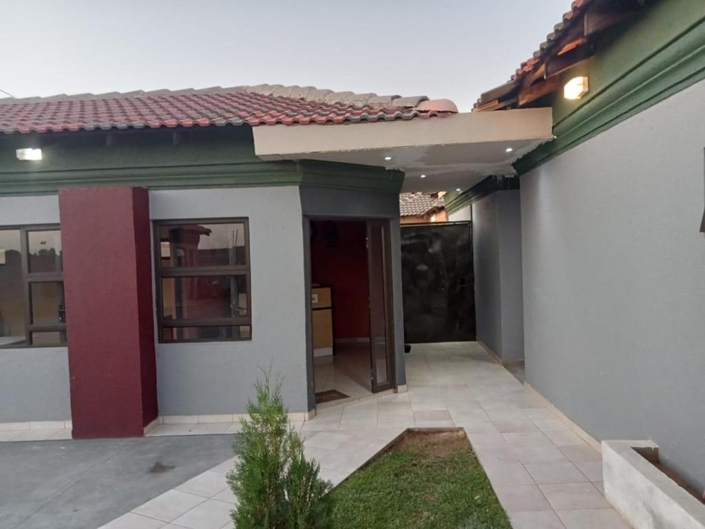 Casa blanca con techo rojo en Kwa-Ntokozo Guesthouse-Tweefontein, en Tweefontein