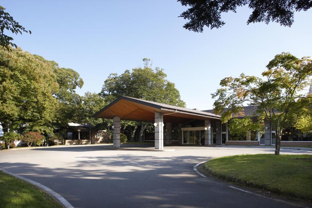 a building with a wooden roof on a road at Karuizawa Prince Hotel West in Karuizawa