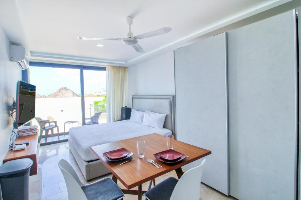 a hotel room with a bed and a table and chairs at One Paralia 405 in Playa del Carmen