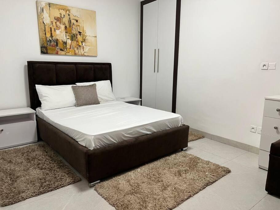 a bedroom with a large bed with white sheets at Superb Urban Oasis in Almadies in Dakar