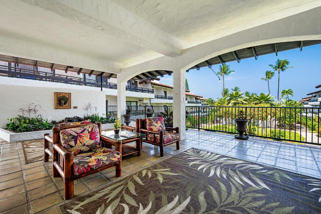 an outdoor patio with two chairs and a table at Casa De Emdeko 222 in Kailua-Kona