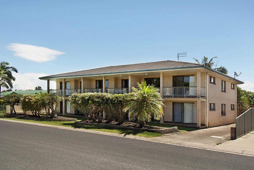 a house with palm trees on the side of the road at Pacific Palms 1, Unit 1, 9-11 Terrace Street Evans Head in Evans Head