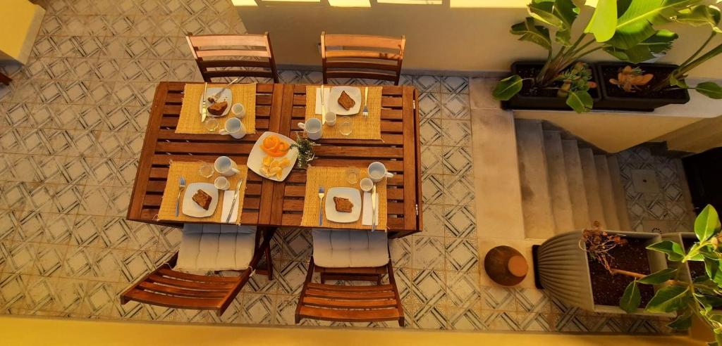 een houten tafel met borden met eten erop bij Casa da Açoteia - Bright City Center Apartment with a Private Outdoor Terrace in Faro