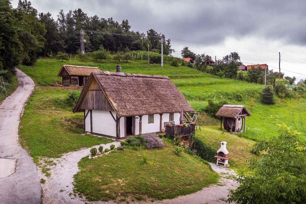 une petite maison sur une colline avec un chien assis sur un banc dans l'établissement Holiday home in Srednje Grcevje - Kranjska Krain 26095, à Srednje Grčevje