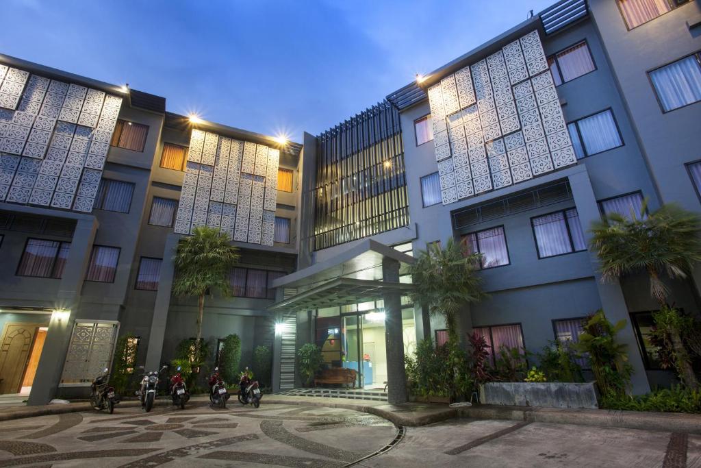 a group of motorcycles parked in front of a building at Dinar Lodge in Bang Tao Beach