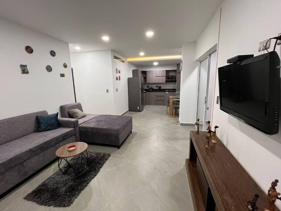 a living room with a couch and a flat screen tv at Hermoso y amplio apartamento en Guatapé in Guatapé