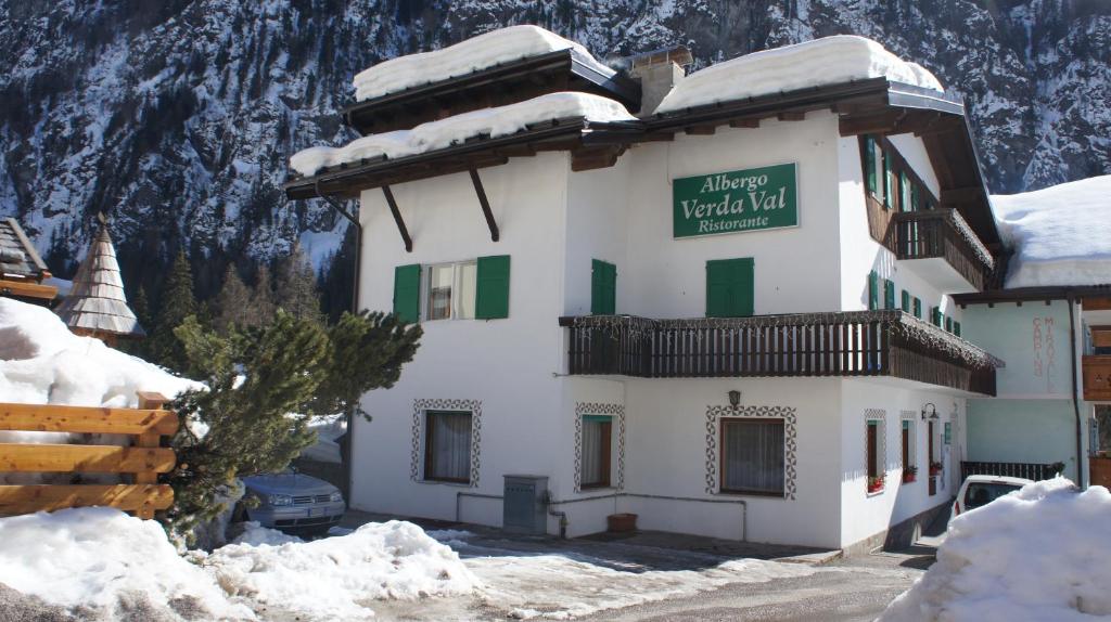 um edifício com um sinal na neve em Verda Val em Campitello di Fassa