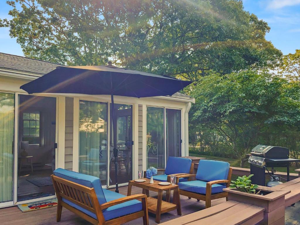 eine Terrasse mit Stühlen, einem Sonnenschirm und einem Grill in der Unterkunft 77 Linden Lane Osterville Cape Cod - - Afterdune Delight in Osterville