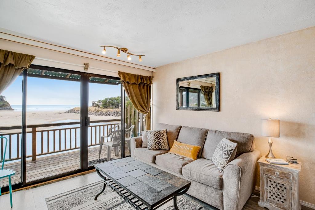 a living room with a couch and a balcony at Sunset Seabreeze in Neskowin