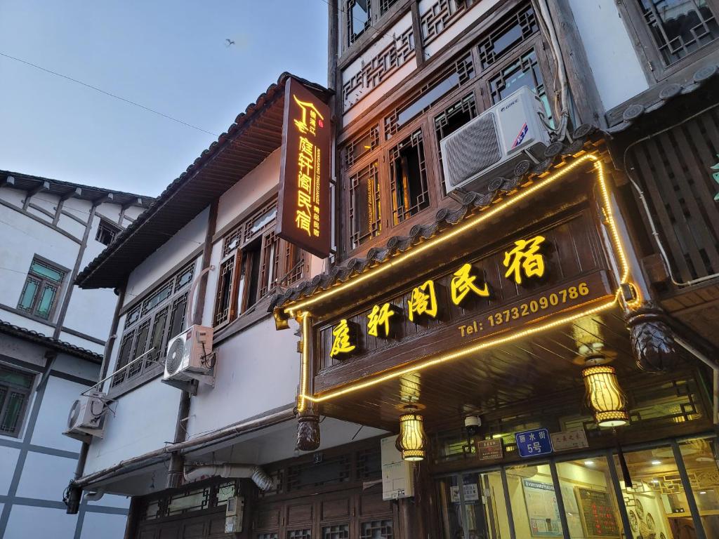 un panneau sur le côté d'un bâtiment dans l'établissement Nanxi JiangTingXuanGe Homestay, à Yongjia