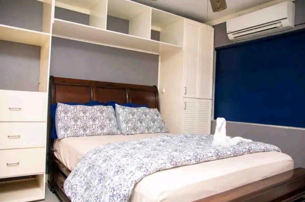 a bedroom with a large bed with a blue wall at Carter's Nest in Kingston