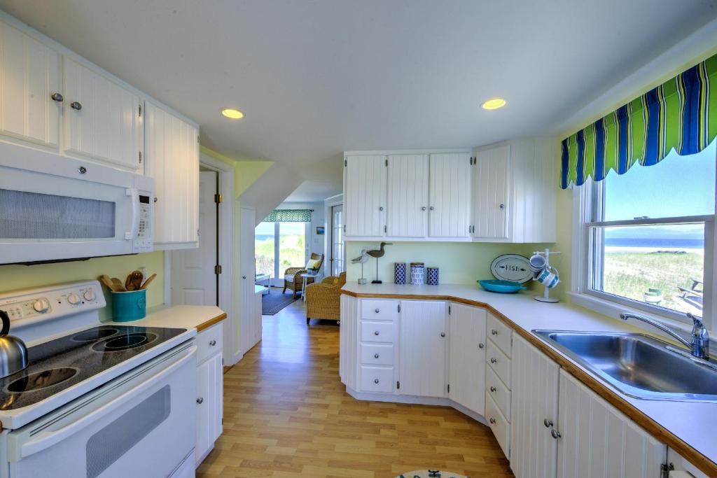eine Küche mit weißen Schränken und einer Spüle und einem Fenster in der Unterkunft 225 J North Shore Blvd East Sandwich Cape Cod - Cape Shore J in East Sandwich
