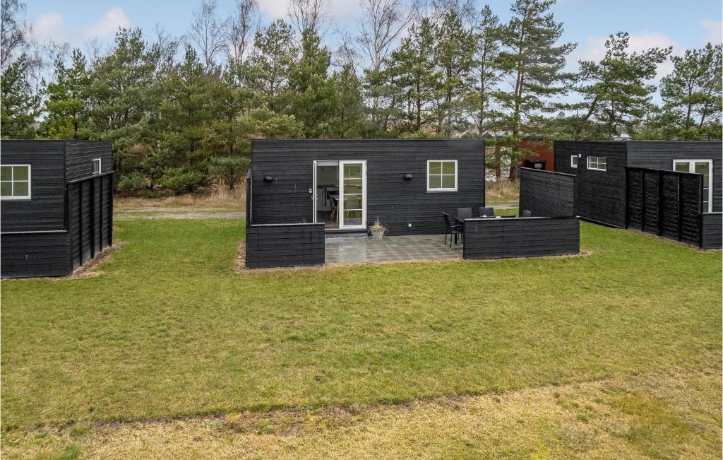 dwa czarne domy modułowe na polu trawy w obiekcie 2 Bedroom Nice Apartment In Vggerlse w mieście Bøtø By