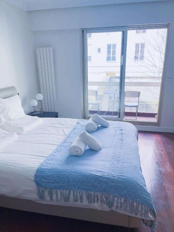 une chambre avec un lit avec deux serviettes dessus dans l'établissement Belle chambre Champs-Élysée, à Paris