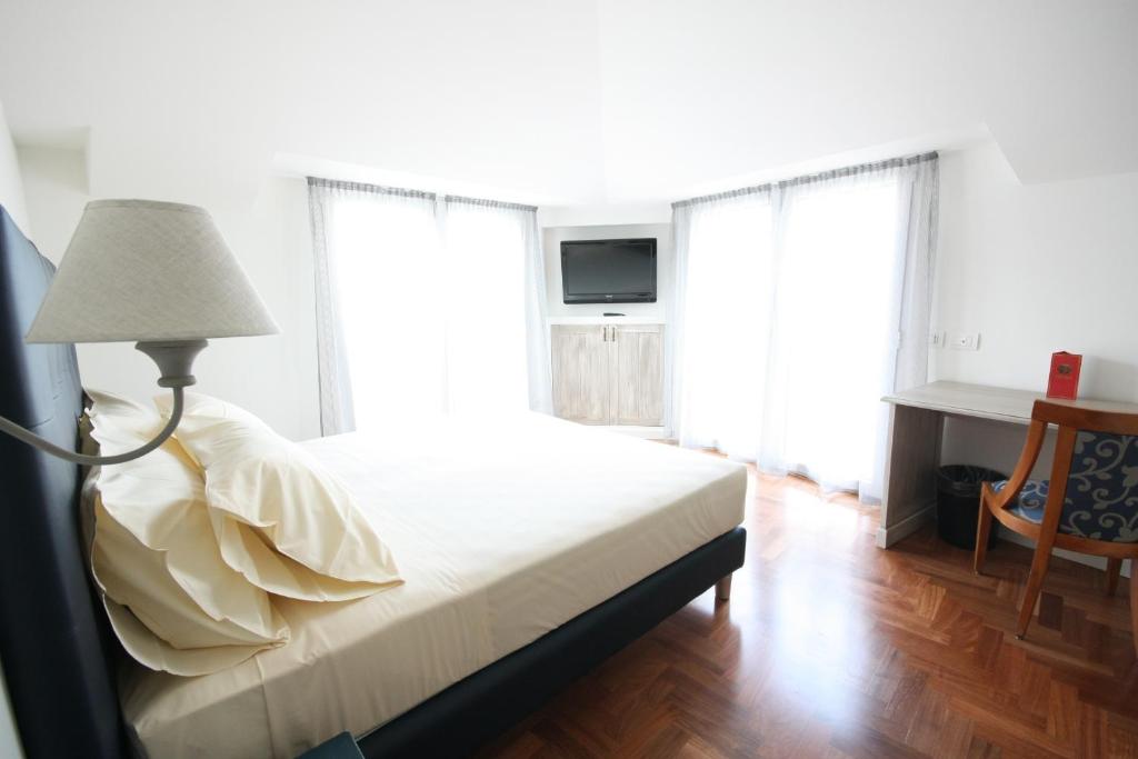 - une chambre avec un lit avec une lampe et 2 fenêtres dans l'établissement Hotel Plinius, à Côme