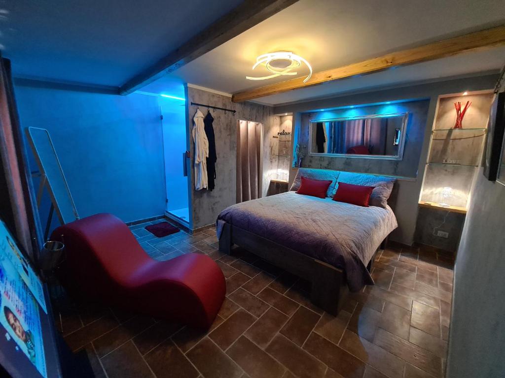 a bedroom with a bed and a red chair at Onlyfor2 un nido d'amore per la coppia in Ronciglione