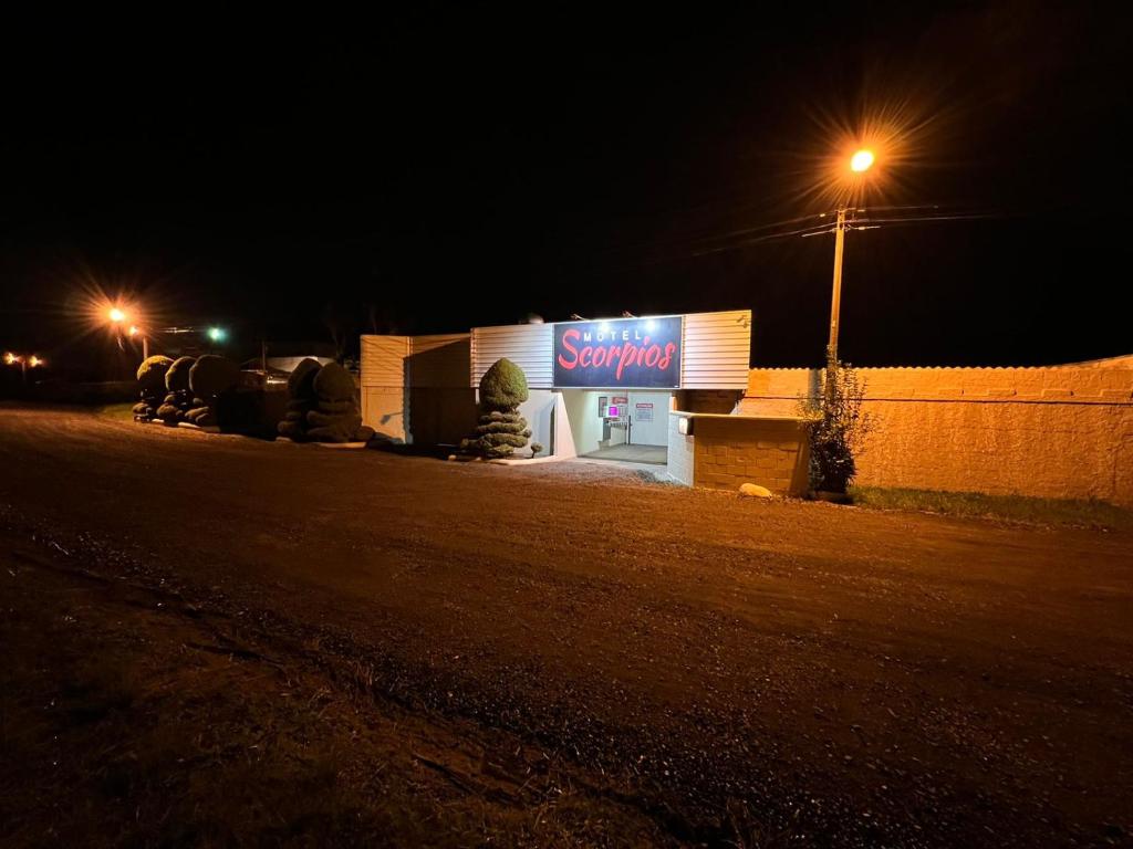 una tienda con un cartel en el costado de ella por la noche en Motel Scorpios, en Lages