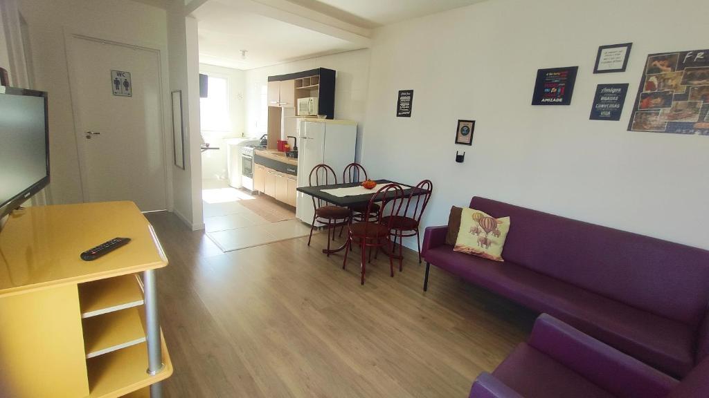 a living room with a couch and a table with chairs at Apto em Santo Ângelo in Santo Ângelo