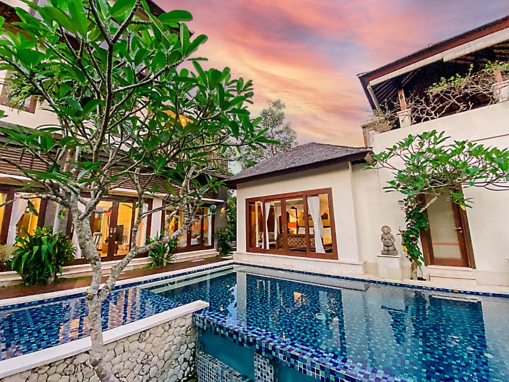 a house with a swimming pool next to a building at Alea Villa by Premier Hospitality Asia in Jimbaran