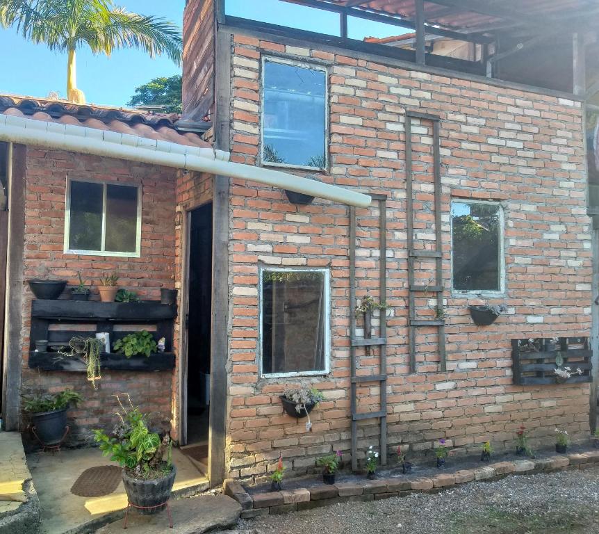Casa com quintal no centro histórico de Mariana/MG في ماريانا: منزل من الطوب مع باب ونوافذ