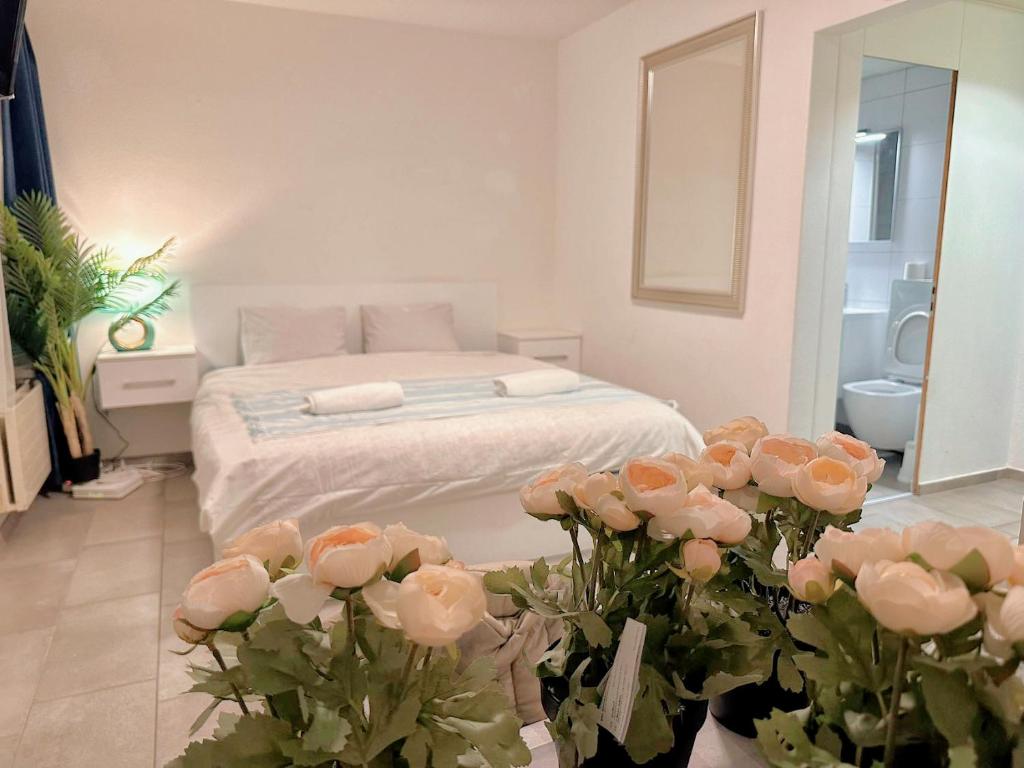 a bedroom with a bed and flowers in front of it at City Center Apartment in Zurich