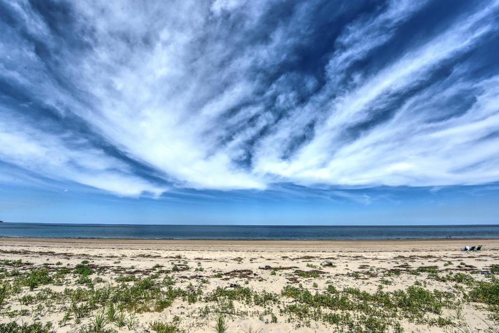 a beach with a cloudy sky and the ocean at 215 Phillips Road Sagamore Beach - Cape Cod in Sagamore Beach
