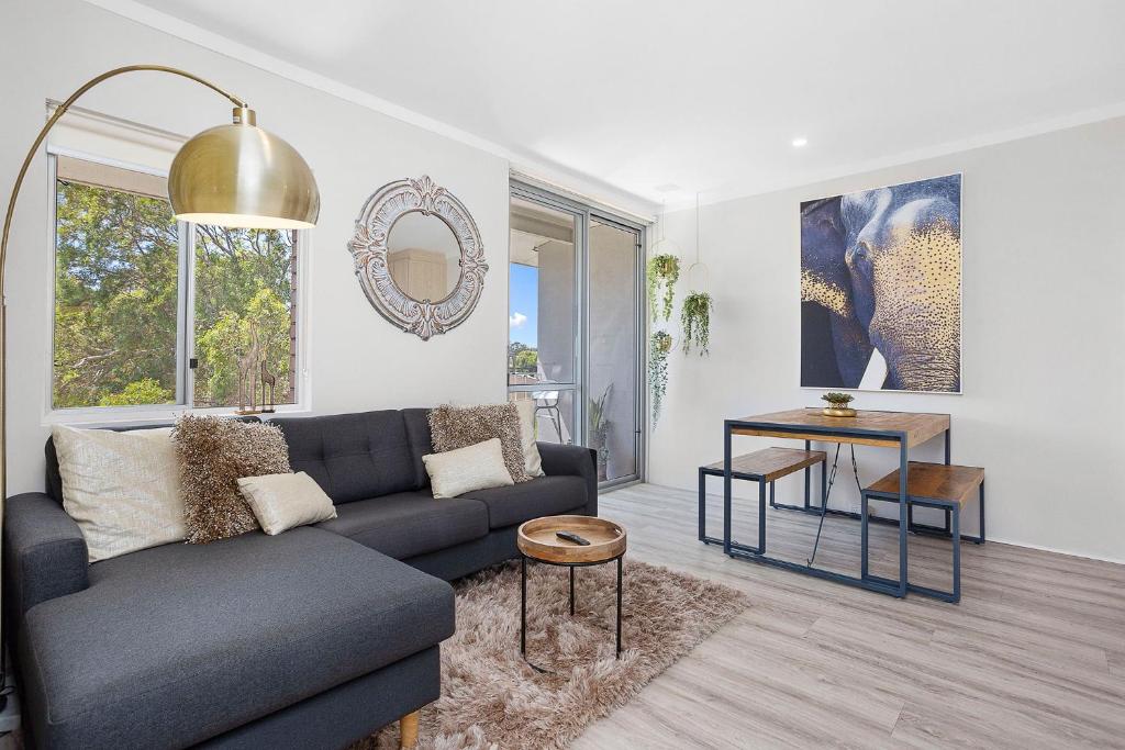 uma sala de estar com um sofá e uma mesa em 12 Calming Coral Beach Beautiful 2brm em Perth
