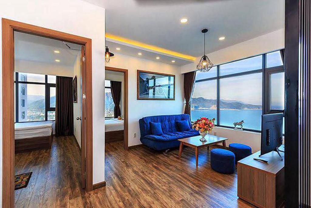 a living room with a blue couch and a television at MySea Nha Trang Apartments in Nha Trang