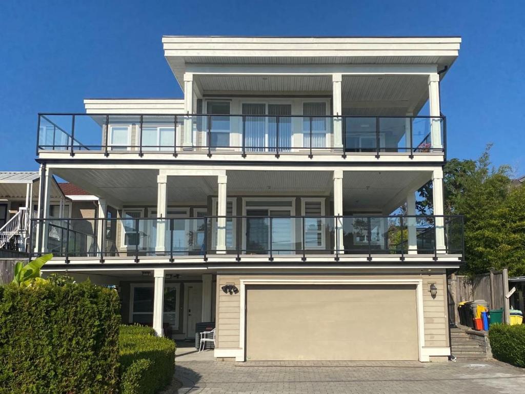 a large white house with a large garage at New two-bedroom legal suite with parking in White Rock