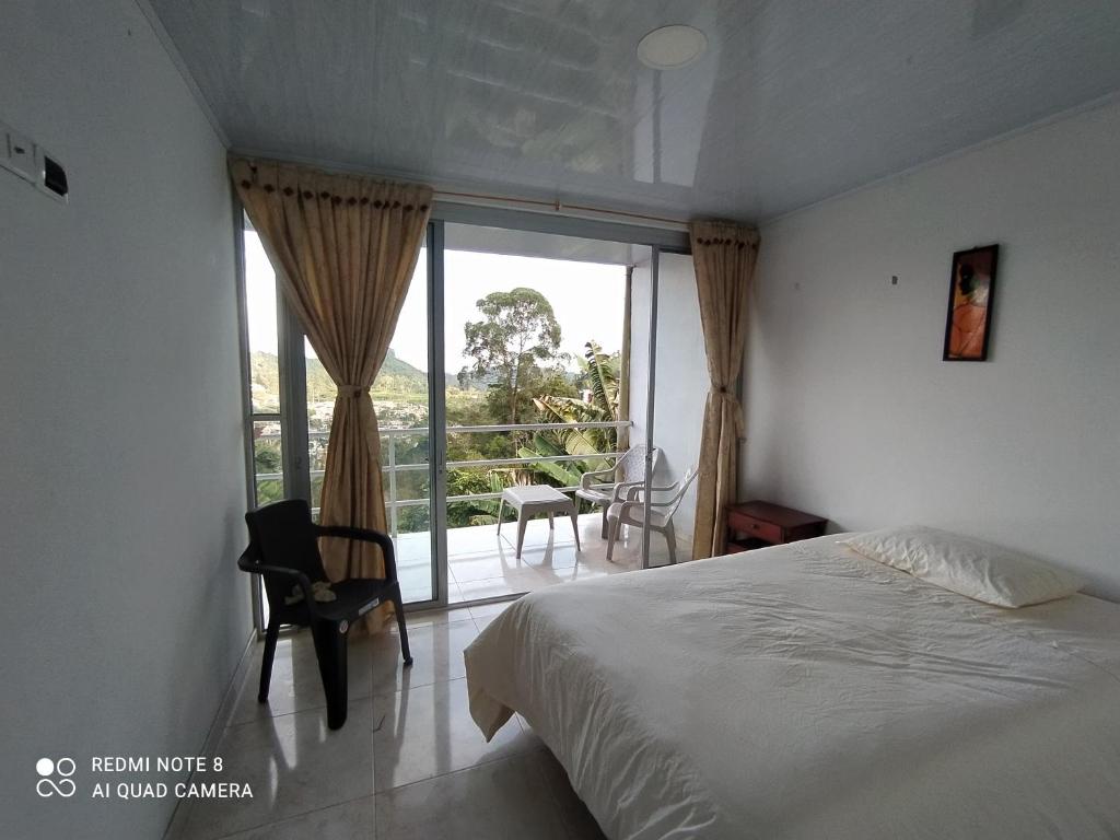 1 dormitorio con cama y ventana grande en Casa turística Santa Helena y el Danubio, en Líbano