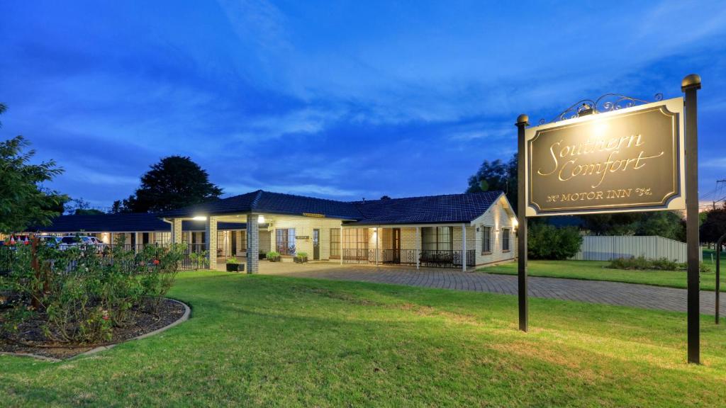 um sinal em frente a uma casa em Southern Comfort Motor Inn em Cootamundra