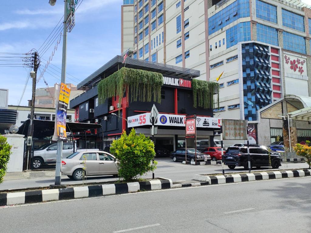 a city street with cars parked in front of a building at Walk Inn in Miri