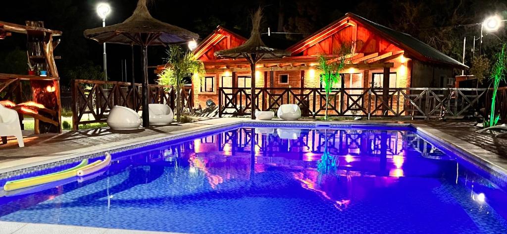 una piscina frente a una casa por la noche en Cabañas las brisas en La Banda