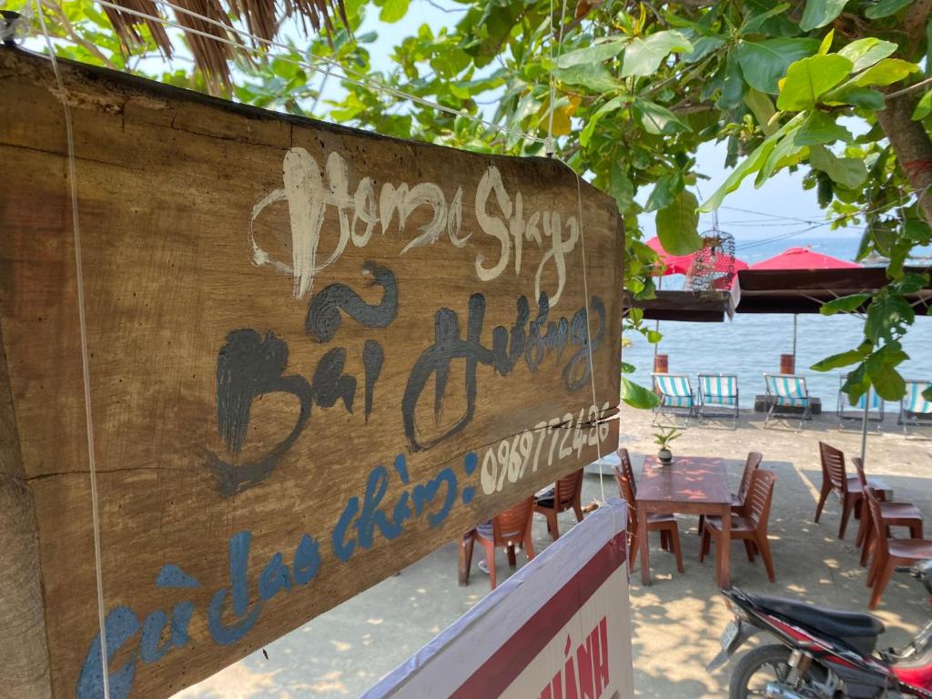 a sign for a restaurant on the beach with writing on it at Bai Huong homestay in Hoi An