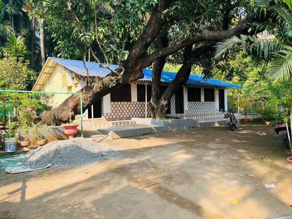 a house with a tree in front of it at Coco land - Near Nagaon Beach, Alibag in Alibaug