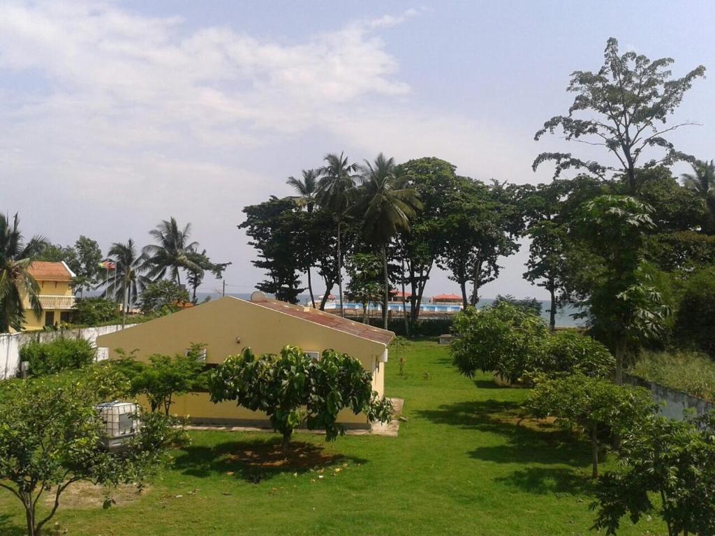 - une vue sur une cour arborée et une maison dans l'établissement E Gravana, à São Tomé