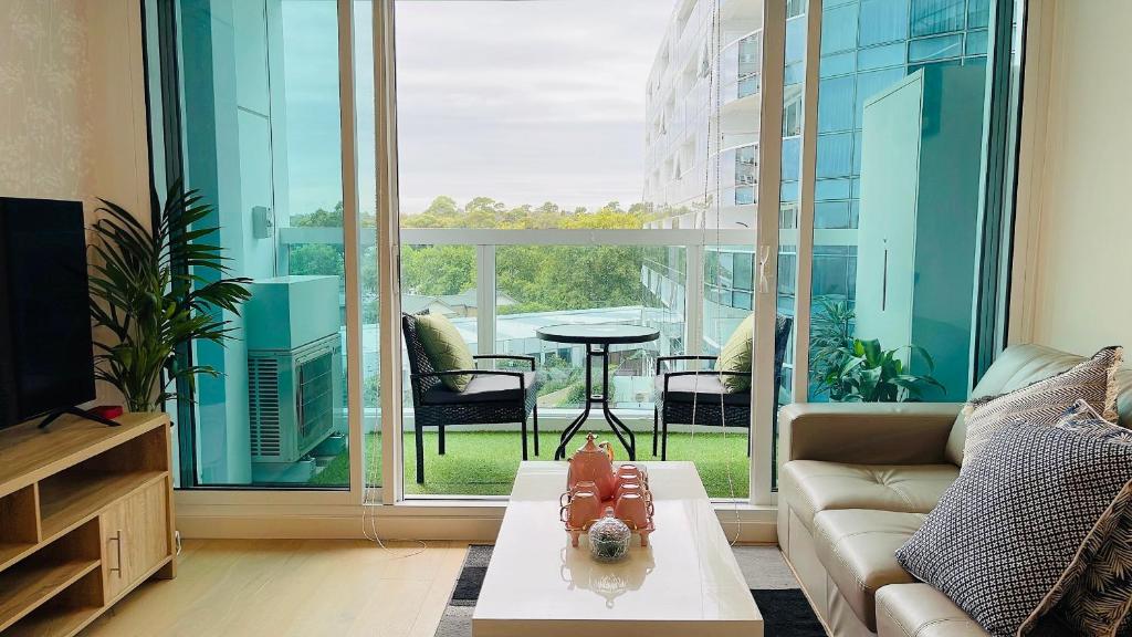 Sweet Home Apartment North Melbourne في ملبورن: غرفة معيشة مع أريكة وطاولة