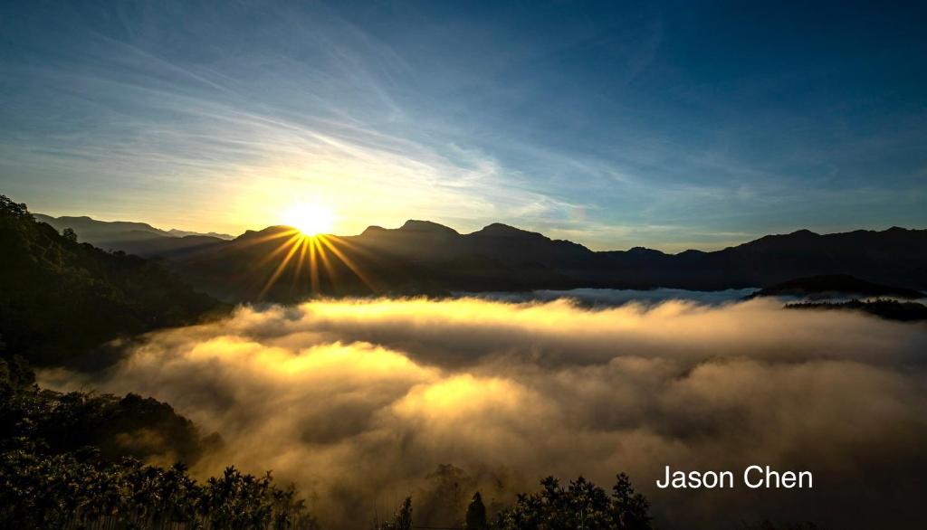 una vista del sol saliendo sobre un valle cubierto de niebla en One Roll Stone Homestay, en Hung-pi-shou